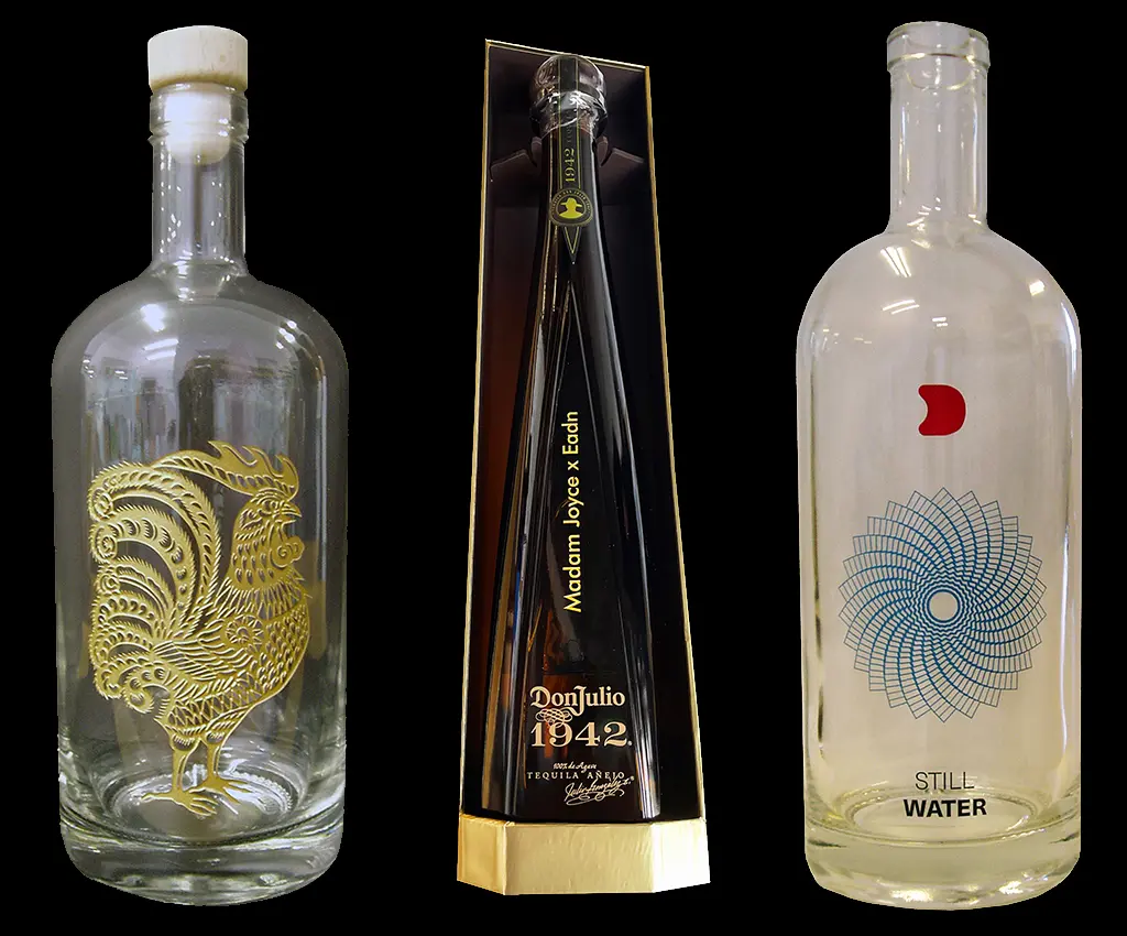 Three decorative glass bottles with detailed engraved designs